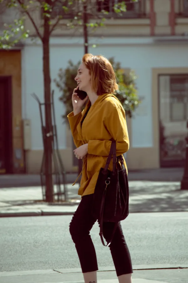 Person checking their phone while walking through the city